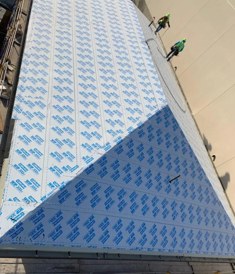 Professional roofers installing underlayment on a metal roof in Lackawaxen